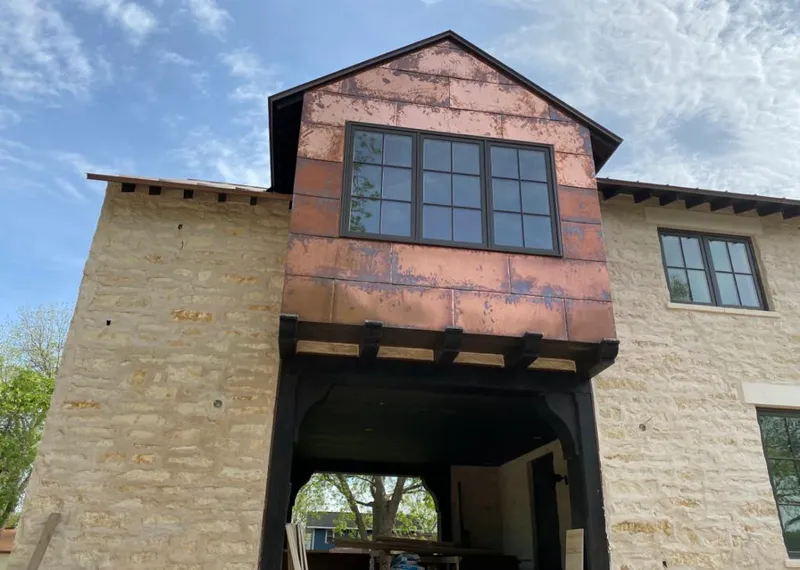Copper metal panel facade on a stone building for Skylight Installation in Oskaloosa